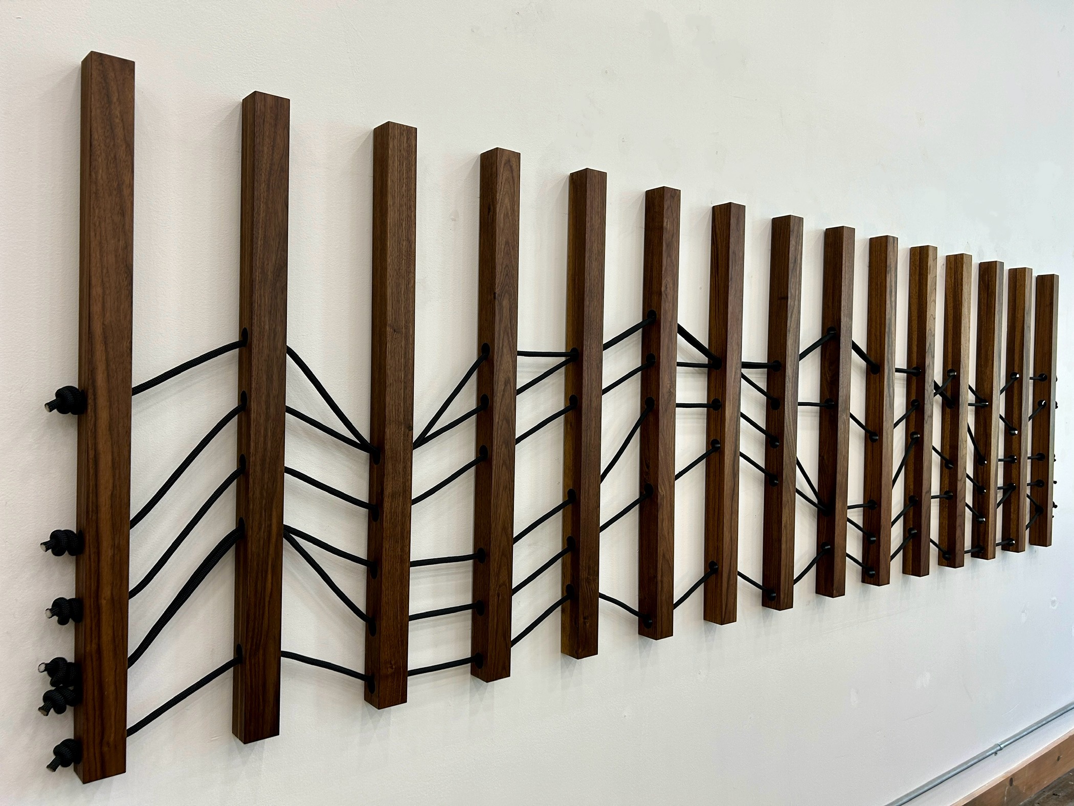 Emily Mann, Ink and Indigo, Wood + Woven Landscape 1, Custom Dimensional Wall Installation, Walnut Slats Woven through with Black Climbing Rope to represent Sedona Mountainscape, approximately 36h x 116w